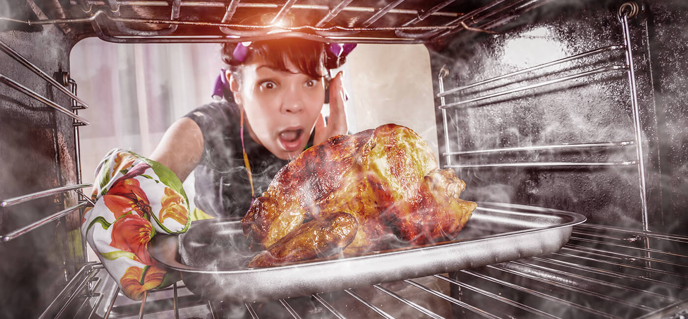 Woman getting turkey out of oven